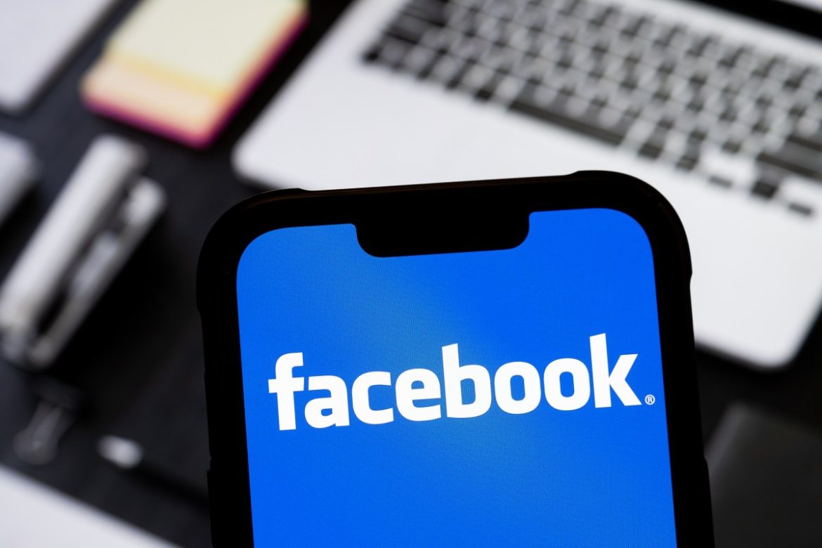 photo illustration of Facebook logo is seen displayed on a smartphone.